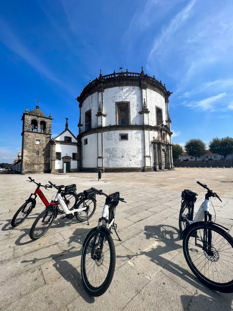 Bike tour with stops at são bento railway station, dom luis i bridge and são francisco church. image shows the group bikes lined up with blue sky in the backgroun
