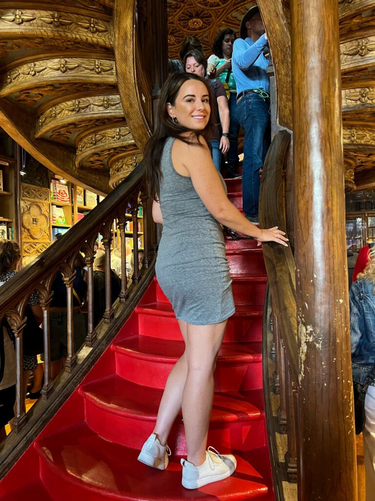 Stopped at Livraria Lello Book Store while we visited Porto. image is of girl standing on famous red staircase.