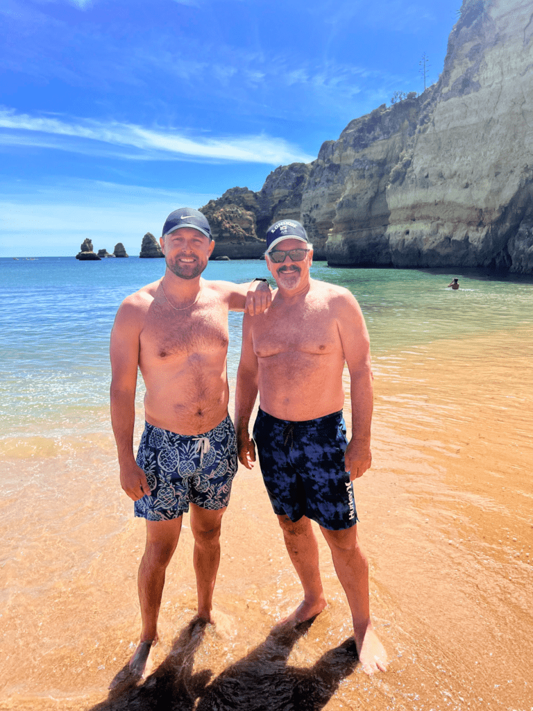 beach time in the algarve with two men standing on the beach