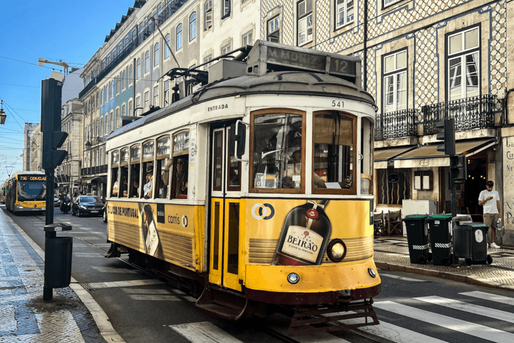 beautiful city picture of lisbon, the Portuguese capital city with cobbled stone streets and bright yellow cable car in the background.