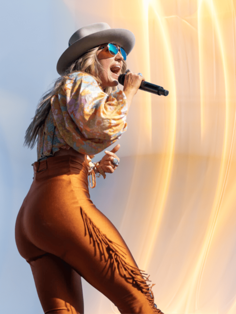 lainey wilson at stagecoach concert in indio with pop of 70s style orange flare pants and printed top