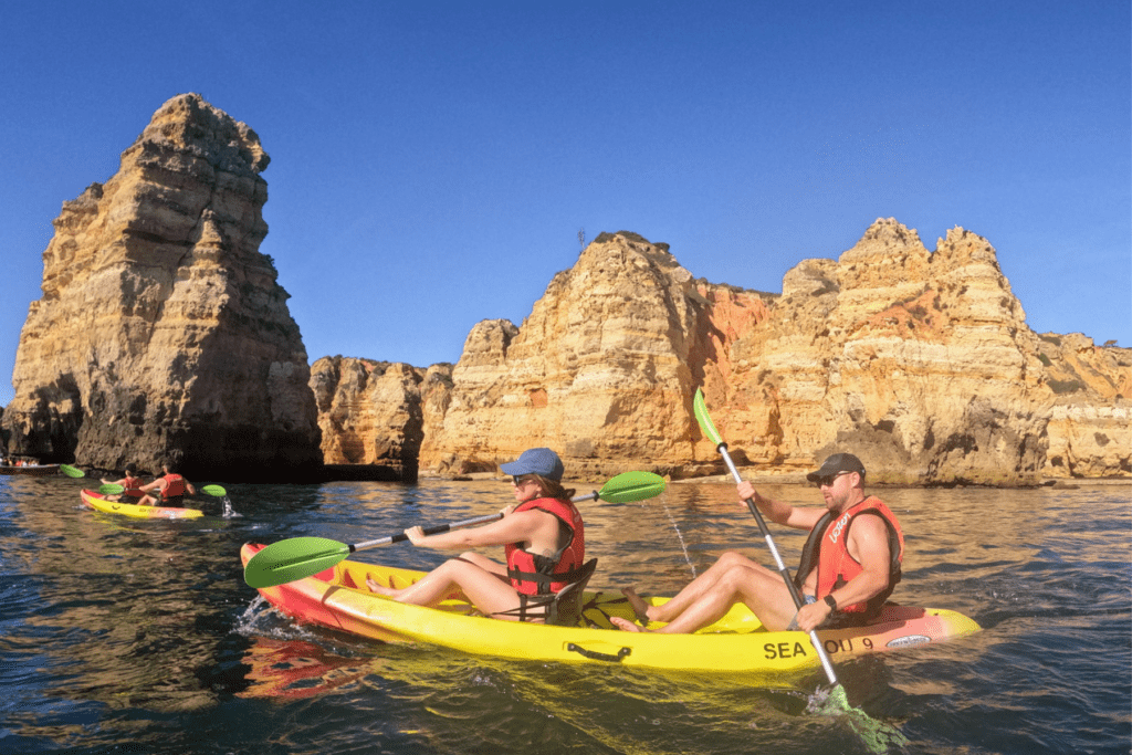 man and woman spending time kayaking to some of Portugals most beautiful beaches