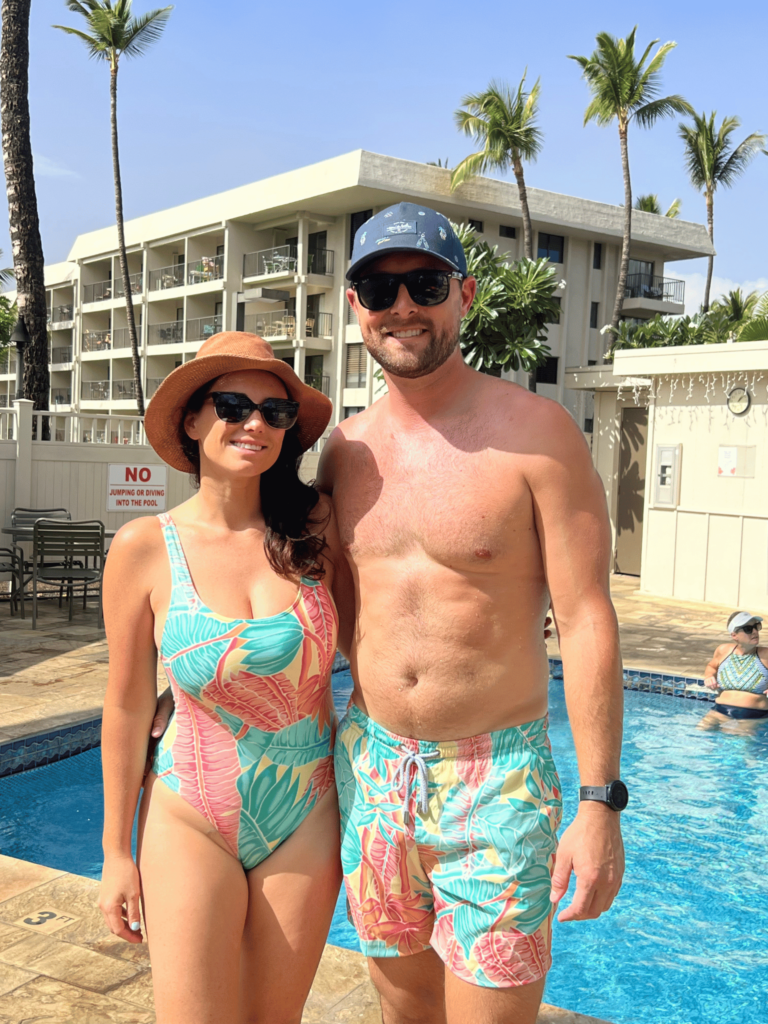 Couple standing in front condo complex in Kihei.  Centrally located town on Maui with condos that offer fitness center, pool, beach access to soft sand beaches and free parking.