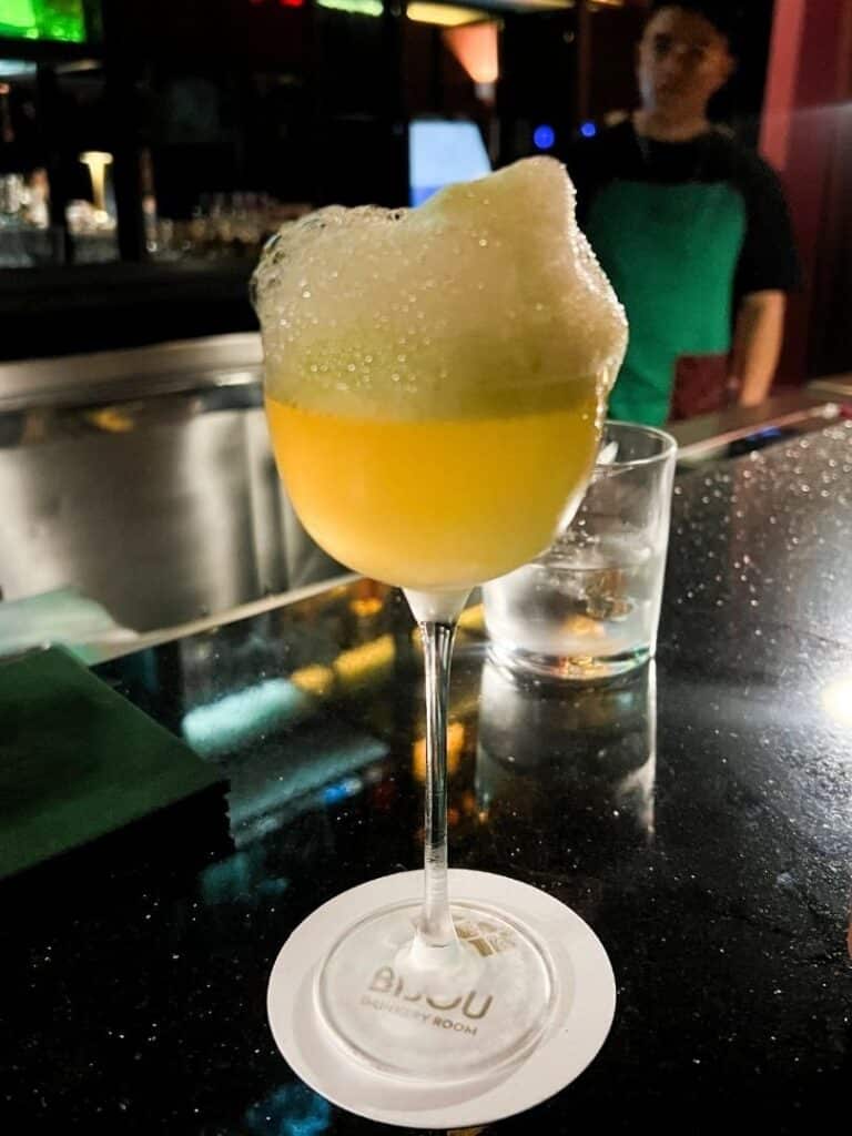 A yellow foaming cocktail at Bijou speakeasy in mexico city
