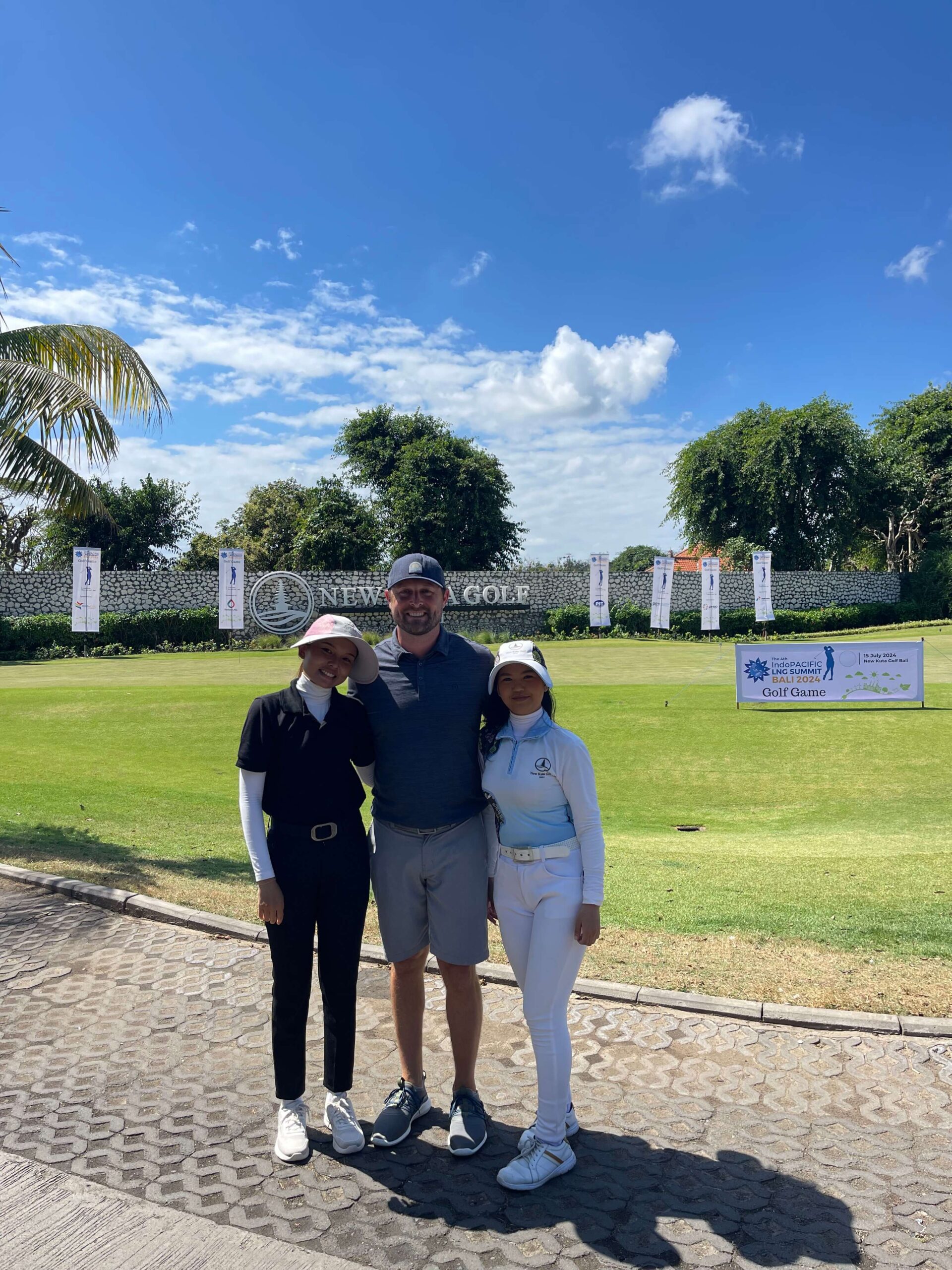 Michael from 2Traveling The World standing with 2 woman golf caddies at New Kuta golf course in Bali