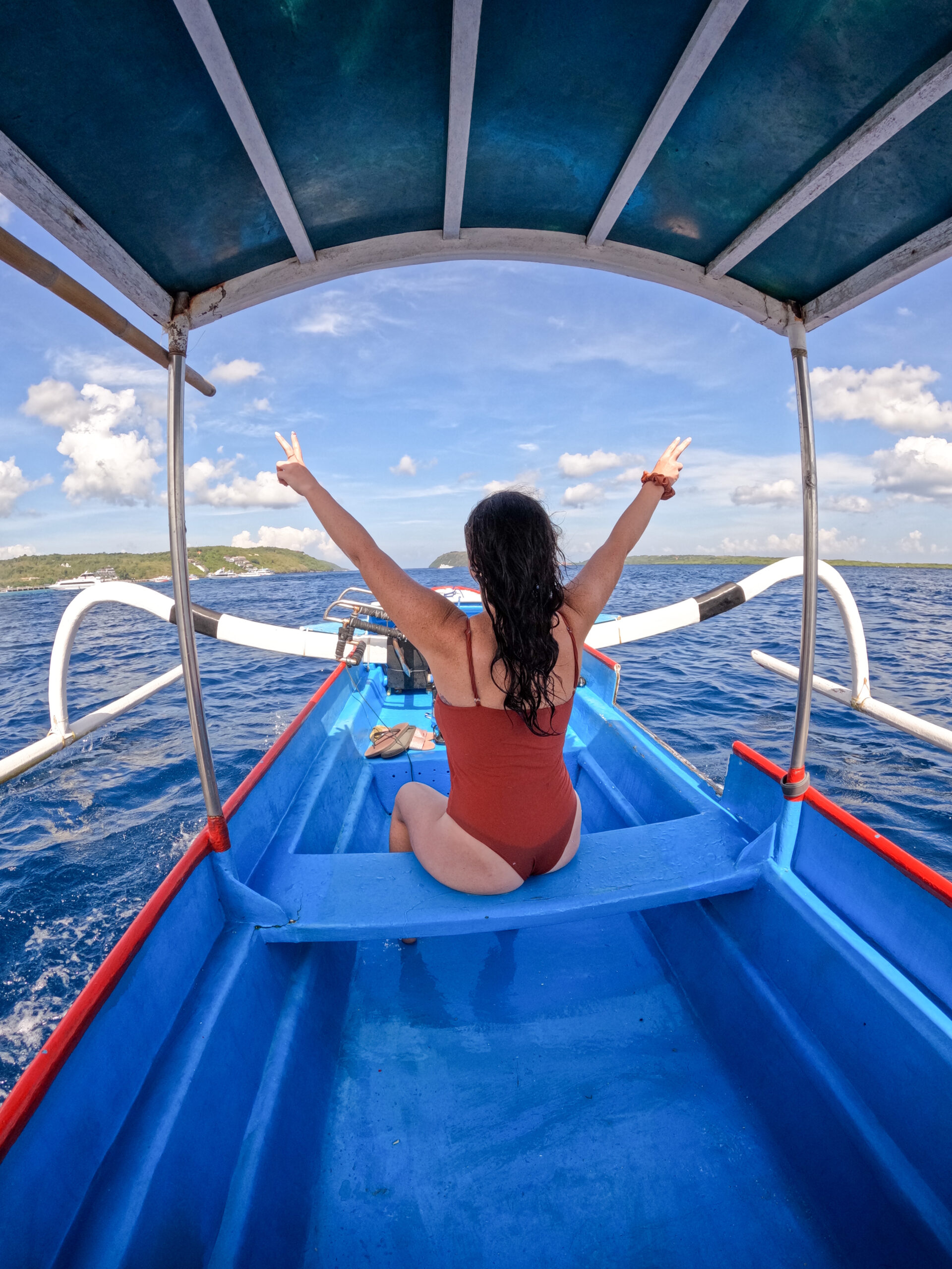 back of woman sitting on a snorkel boat on nusa islands.